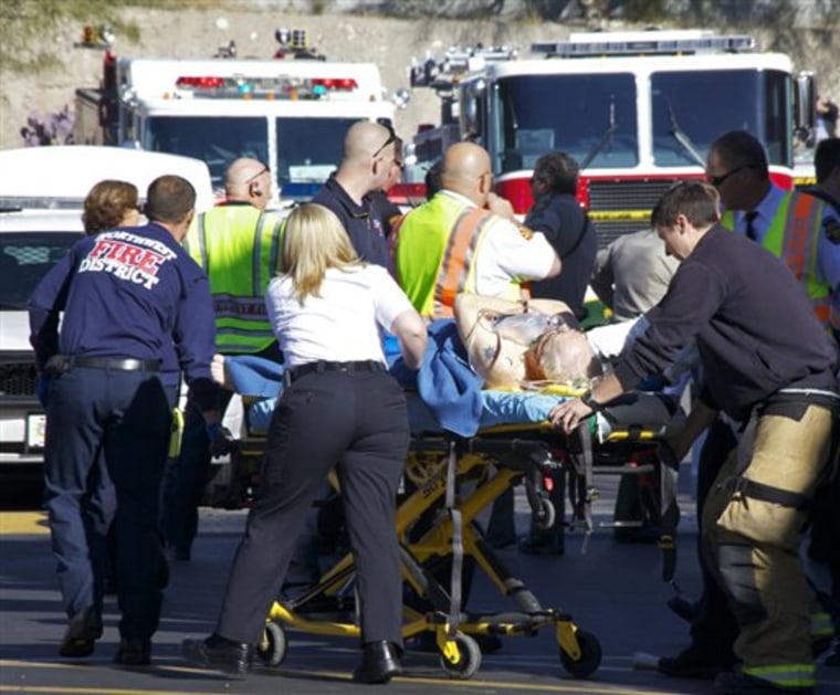 Emergency personnel attend to a shooting victim outside a shopping center in Tucson, Ariz. on Saturday where U.S. Rep. Gabrielle Giffords, D-Ariz., and others were shot as the congresswoman was meeting with constituents. 